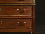 an antique wooden chest of drawers with brass hardware and a black background