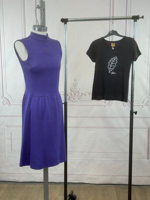 une robe violette et noire exposée dans une pièce aux murs blancs