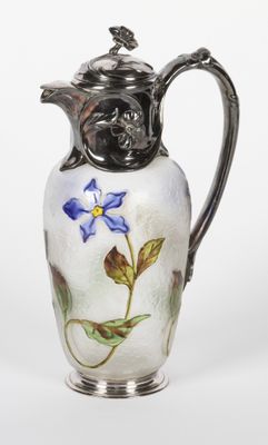un pichet en verre orné d'une fleur bleue