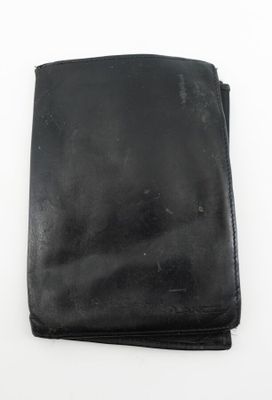 un portefeuille noir vide posé sur une surface blanche, avec un fond blanc