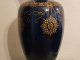 a blue vase with gold decorations on it on a table