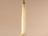 a white marble column with a gold top on a beige background