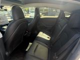 the back seats of a white car with black seats in it