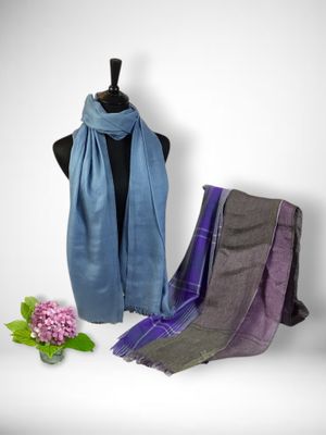 a close up of a scarf on a mannequin with flowers in the background