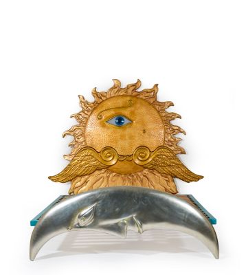 a gold and silver brooch with a blue eye on it