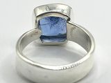 silver ring with a blue stone on top of it on a white surface