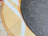 a round table with a black top on a tiled floor