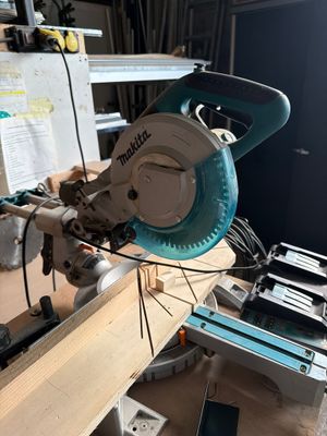quelqu'un utilise une scie circulaire pour couper une pièce de bois