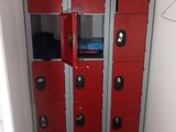 several red lockers are in a small room with a door open