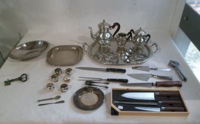 a table with silverware on it and a tray with knives and spoons