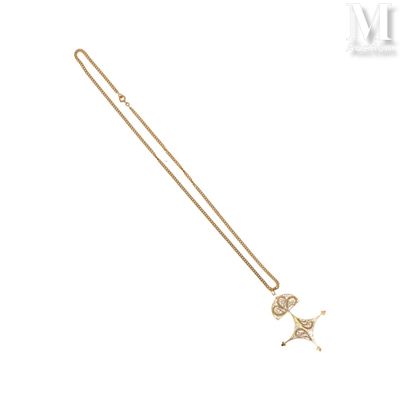 Gros plan sur un collier en or orné d'un oiseau
