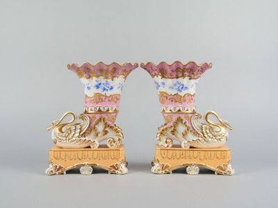 pair of pink and white vases with gold accents on stands