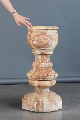 une femme debout à côté d'un grand vase