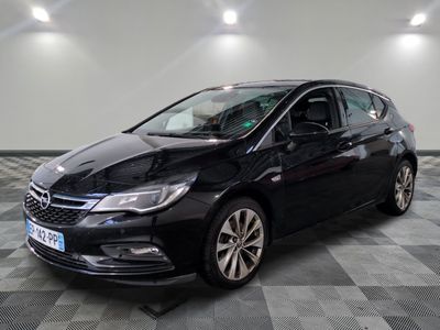 L'Opel noire est garée dans une grande pièce au sol carrelé en damier.