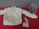 une veste blanche et une paire de chaussures marron posées sur une table rouge