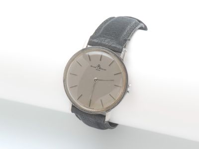 une montre-bracelet posée sur une surface blanche