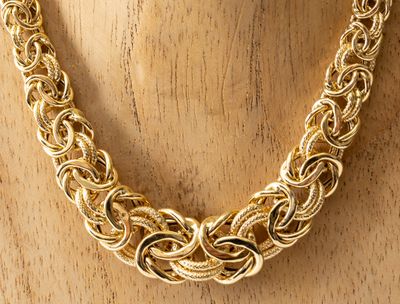 un gros plan d'un collier à chaîne en or sur un mannequin