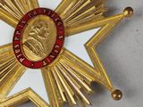 an image of a gold medal with a red and white star on it