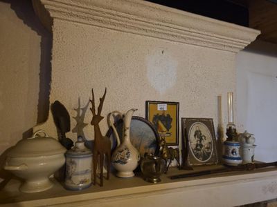 une étagère sur laquelle sont disposés de nombreux vases et tableaux
