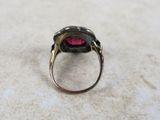 a close up of a ring with a pink stone in it