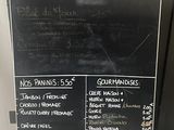 a chalk board with a menu on it on the sidewalk
