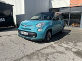 La petite voiture bleue est garée devant un immeuble.