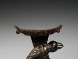 une image représentant un oiseau sur un piédestal, avec un autre oiseau perché sur sa tête
