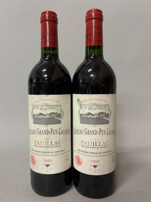two bottles of red wine sitting next to each other on a table