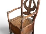 a wooden chair that has a harp on the back of it