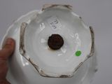 a person holding a white plate with a brown object in it