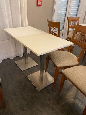 une table blanche et quatre chaises dans une pièce