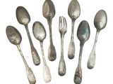 six silver spoons and a fork are arranged in a circle