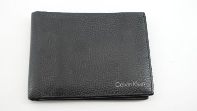 un portefeuille en cuir noir posé sur une table blanche