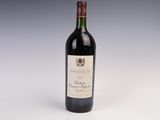 une bouteille de vin rouge posée sur une table blanche
