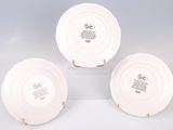 three white plates with black designs on them sitting on a white surface