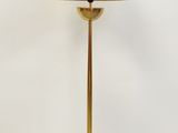 une lampe de table en laiton surmontée d'un abat-jour blanc