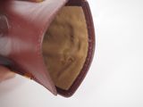 a person holding a pair of brown shoes in their hand
