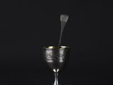 a silver cup with smoke coming out of it on a black background