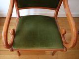a wooden chair with a green upholstered seat