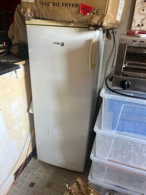 boxes stacked on top of a refrigerator in a room with a laptop