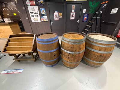 trois tonneaux en bois posés les uns à côté des autres sur le sol