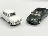 deux voitures jouets assises l'une à côté de l'autre sur une surface blanche