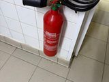 a fire extinguisor attached to a wall in a bathroom