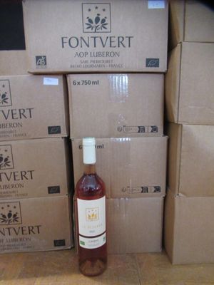 une bouteille de vin posée à côté d'une pile de cartons
