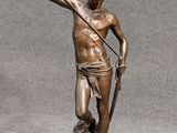 statue en bronze représentant un homme avec une lance et un chien