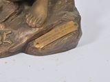 a bronze statue of a bear holding a teddy bear on a rock