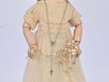 an old fashioned doll with a hat and dress on a white background