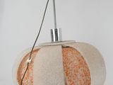 an orange and white lamp that is on a white table