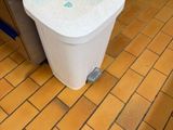 une poubelle blanche posée par terre dans une cuisine