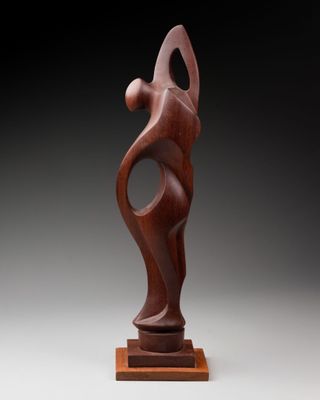 a wooden sculpture of a woman holding a baby in her arms